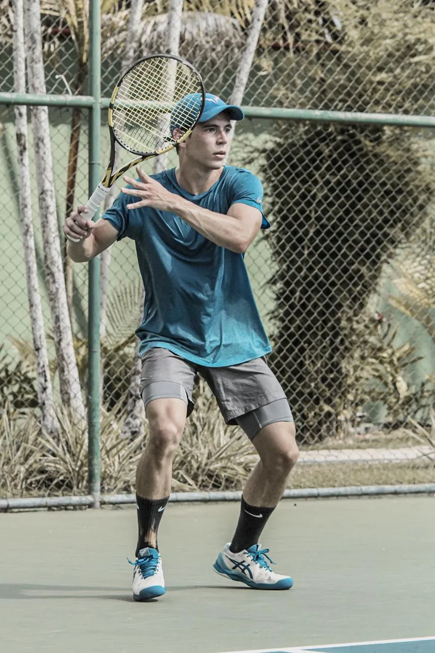 Teenage Arthur on court, setting up a forehand